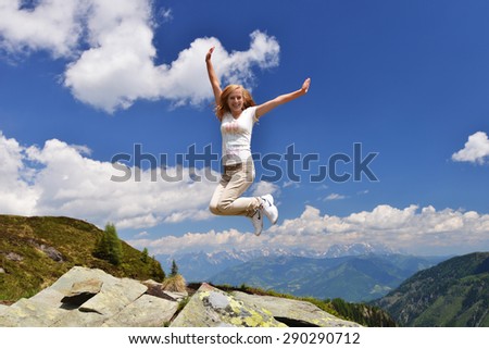 young woman on top of mountain,  background  of sky and clouds