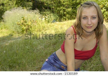nice girl in red shirt on the grass-plot