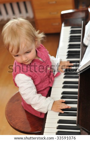 beautiful little girl plays  piano