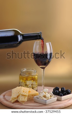 wine bottle and cheese on gold background