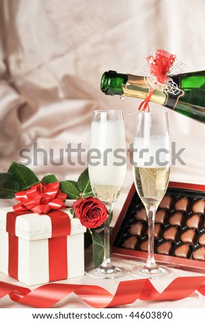 gifts  in box with red ribbon and champagne  close-up