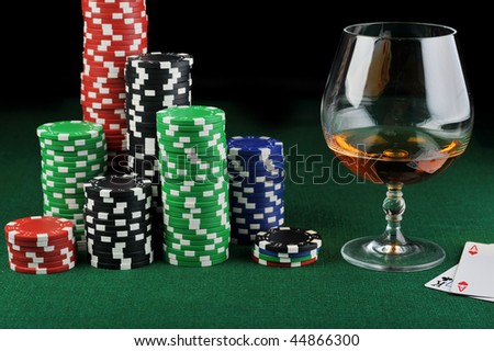 color chips for gambling, drink and playing cards on green