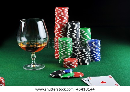 color chips for gambling, drink and playing cards on green
