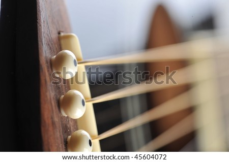 Detail of an acoustic black guitar with the strings and the sound hole