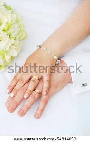 stock photo 2 hands with wedding rings and flowers