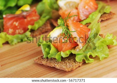 pieces of  salmon with lemon  lettuce   and small loafs
