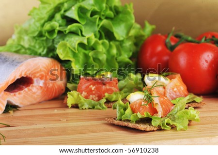 pieces of  salmon with lemon  lettuce   and small loafs