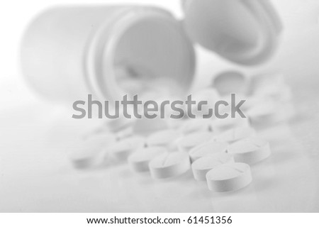 Open   prescription bottles  and white tablets  scattered on  table