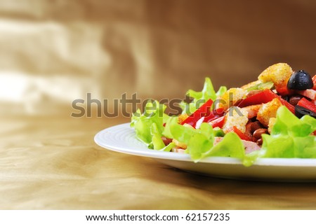 Fresh and tasty salad  on plate, golden background