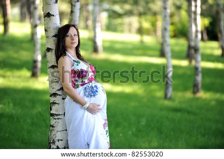 beautiful  future mom standing near  tree.  summer\'s day.