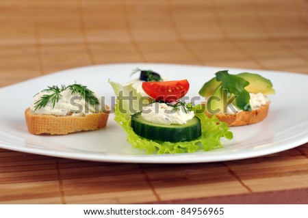 Tasty small sandwich from vegetables and cheese on dish