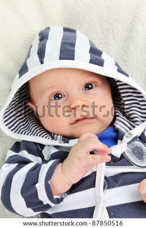 Adorable little  boy in striped blouse on  blanket