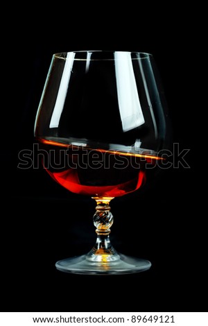 elegant  glass of cognac on table. black background