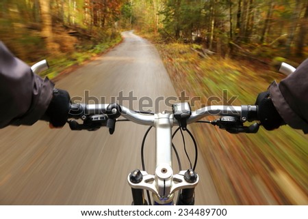 man on bicycle is driving fast in forest