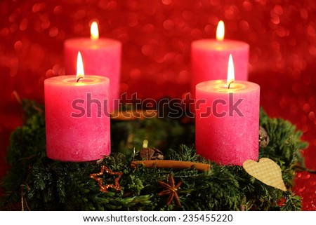 four candles with flame and red background
