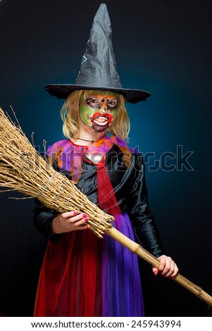 Scary witch with colored skin on dark background
