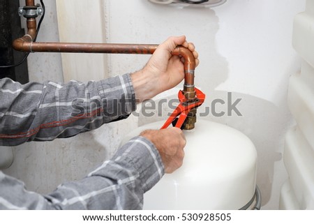 worker is mounting a heating pipe in heating room