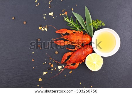 Delicious fresh lobster on dark vintage background. Seafood with aromatic herbs, spices and vegetables - healthy food, diet or cooking concept