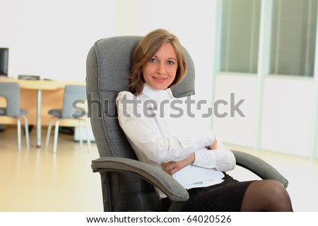 Woman sitting on chair and holding papers with pen