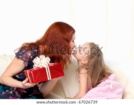 Girl gives present to mother and kissing