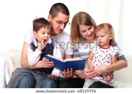 Happy family reading a book on sofa