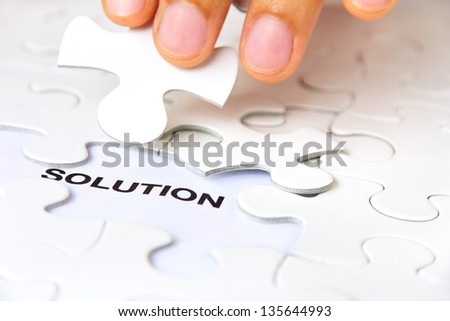 hand holding a puzzle piece, solution concept