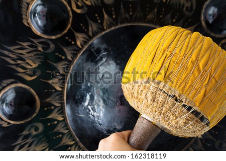 Hand hit big gong in temple