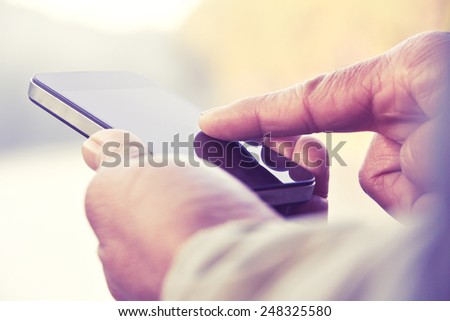 Older man texting on his smartphone