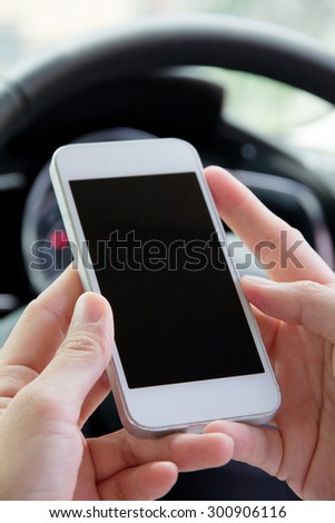 Young woman holding mobile device in the car