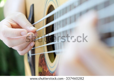 Guitar player,close up of 5 string acoustic bass guitar.