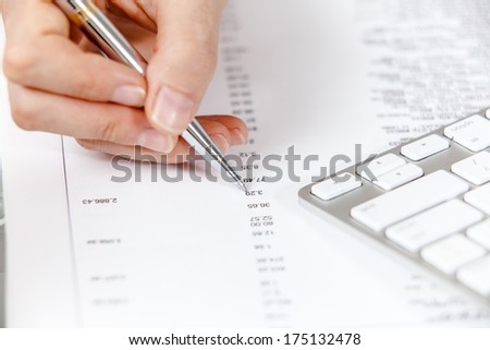 Financial data analyzing. A calculator, pen and financial statement.