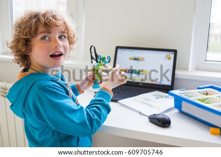 boy in robotics  school  makes robot managed from the constructor, robot programming, child learn to build from the plastic details, boy on computer programs his robot.