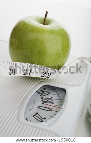 Apple and tape measure on a scale