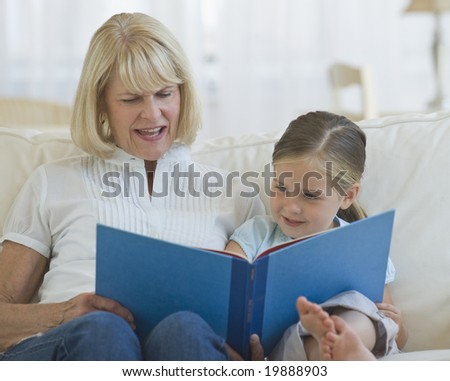 Grandmother reading a book to her grand daughter