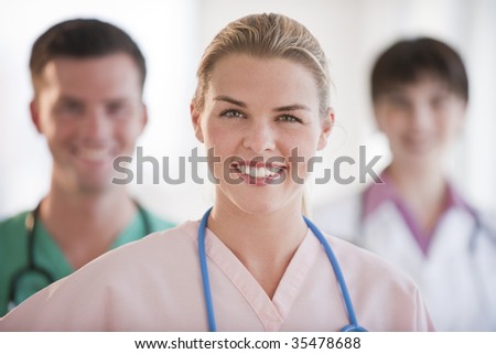 A group of doctors are smiling at the camera.  Horizontally framed shot.