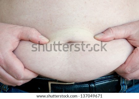 Close up of hands squeezing a fat roll on a mans belly