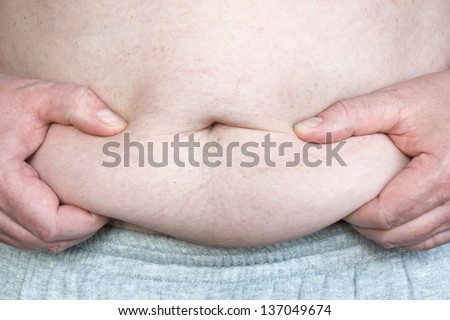 Close up of hands squeezing a fat roll on an mans belly