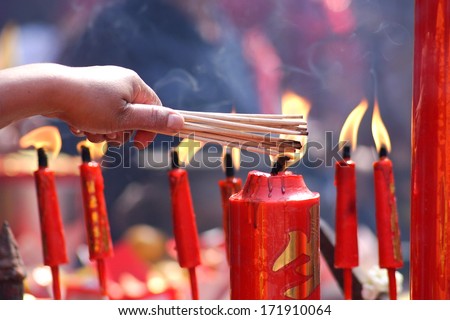 People prayers burning incense sticks on a red candle fire