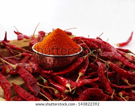 red chillies with red chilly powder on white background
