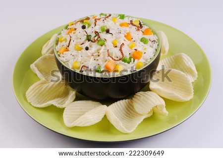 A bowl of rice with vegetables,bowl full of rice with potato chips