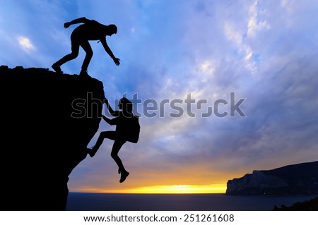 The joint work teamwork of two men travelers help each other on top of a mountain climbing team, a beautiful sunset landscape