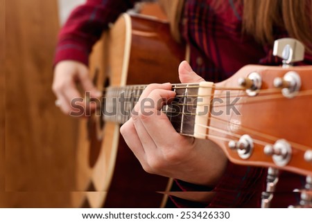 woman's hands playing acoustic guitar, close up. Playing acoustic guitar girl or woman with long hair by fingers. finger position on the chord. selective focus image