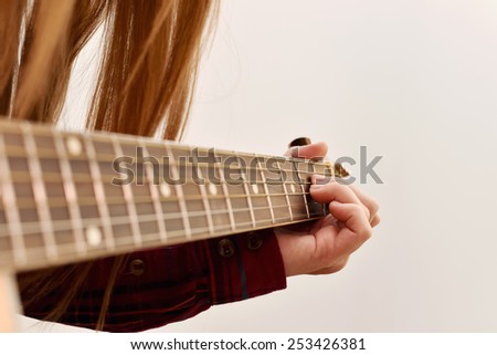 woman's hands playing acoustic guitar, close up. Playing acoustic guitar girl or woman with long hair by fingers. finger position on the chord. selective focus image