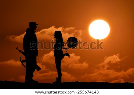 Silhouette of peace and love versus war and anger. No war, soldier and girl, weapon and flower toy, peace in world, sunset, landscape