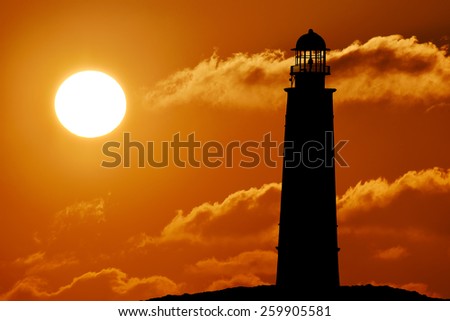 Silhouette of lighthouse above the sunset, sun, sunlight, sunrise Seascape with lighthouse at sunset