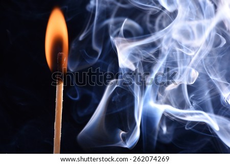 Burnt match in a smoke on a black background. cyan smoke comes out from an extincted match. fire flame match and smoky match