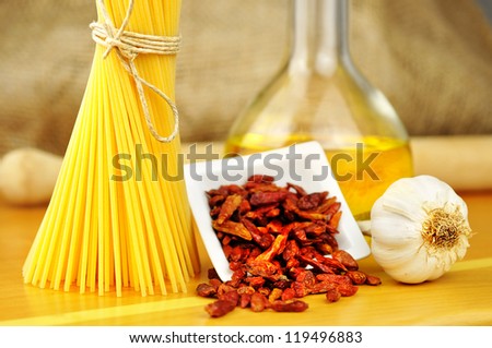 Raw ingredients for spaghetti aglio, olio e peperoncino (garlic, oil, and chili), selective focus