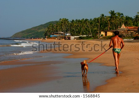 man and his dog on the beach, goa India.