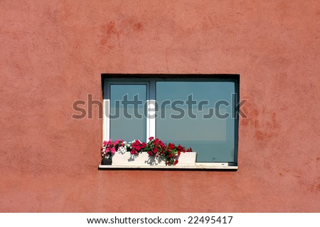 An Italian window is decorated with flowers in the summer.