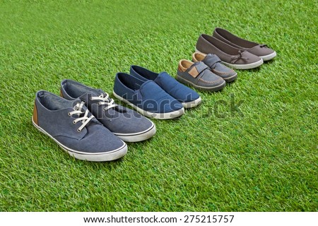 Family shoes standing  on green summer grass in a row